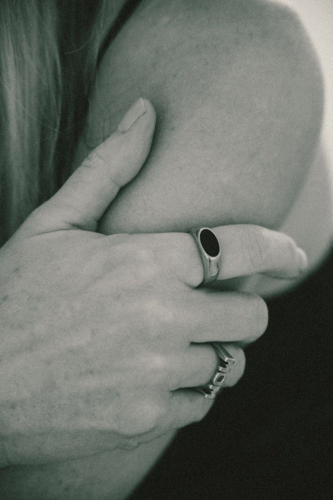 Detail einer Hand mit Ringen auf der Schulter