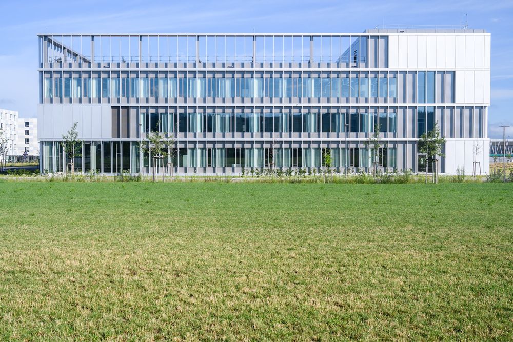 Fassade des Neubaus über einer Wiese