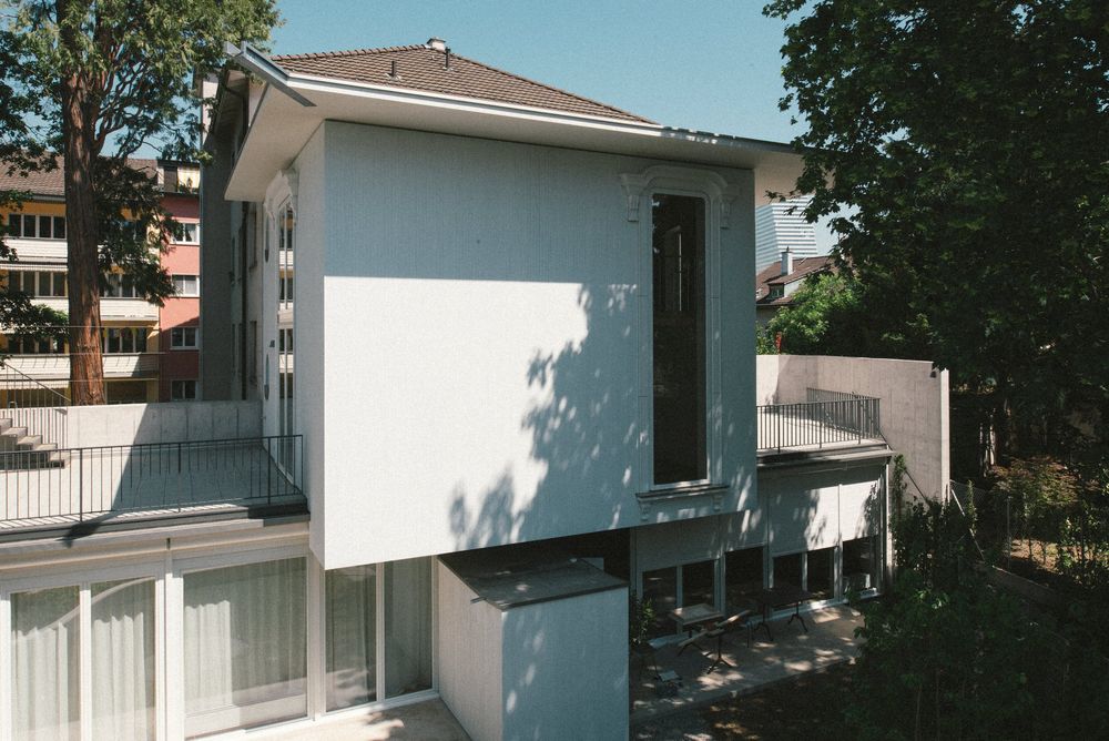 Weisses Haus mit Garten und Bäumen von schräg oben
