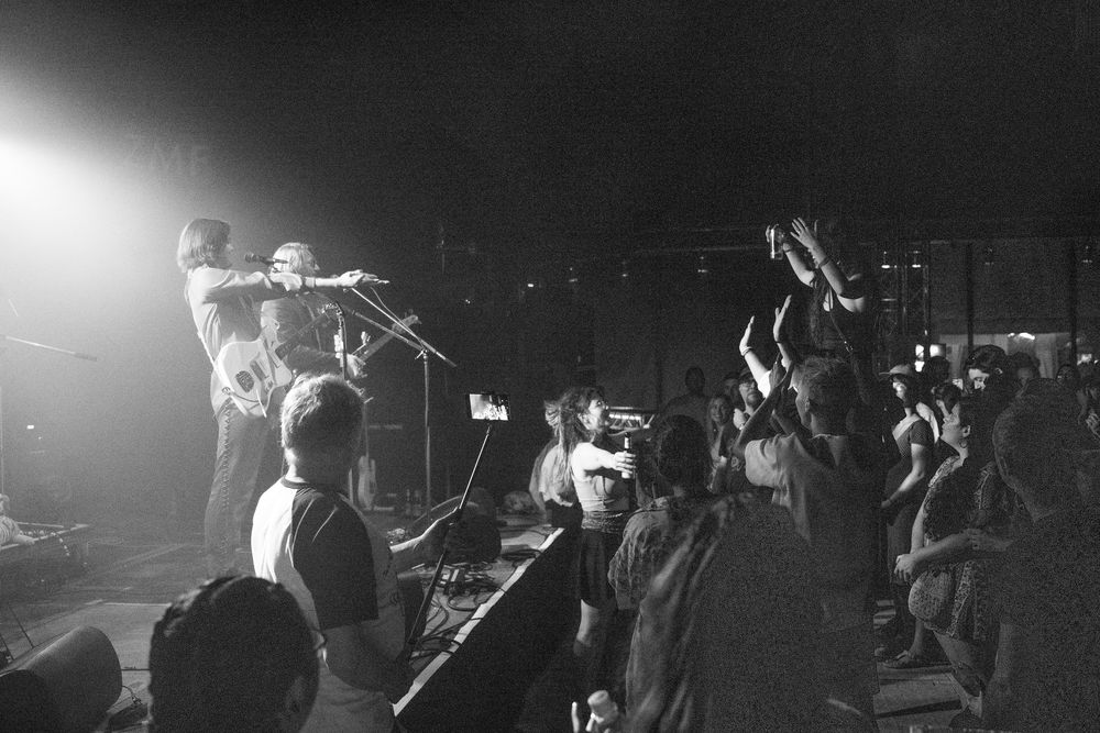 Band und Publikum mit erhobenen Händen, schwarzweiss
