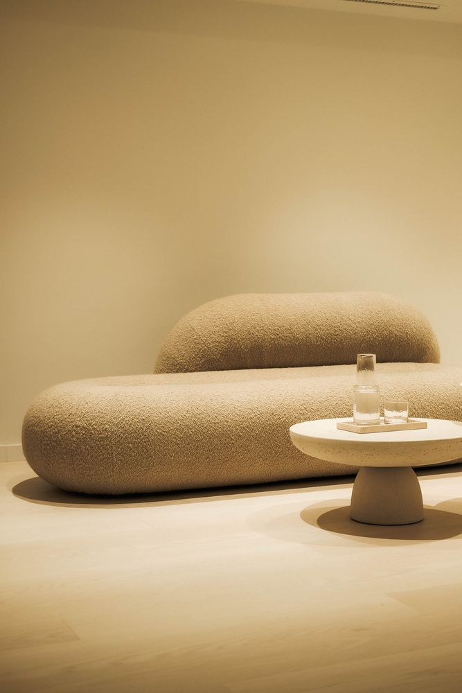 Geschwungenes Sofa und runder Tisch in warmem Licht