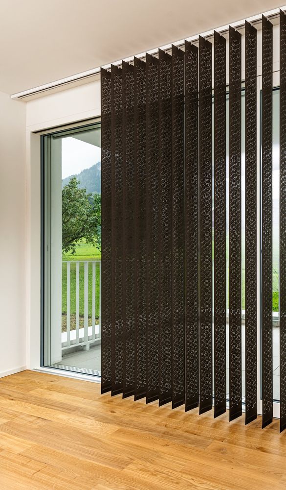 Dunkle gemusterte Lamellen vor einer Fenstertür