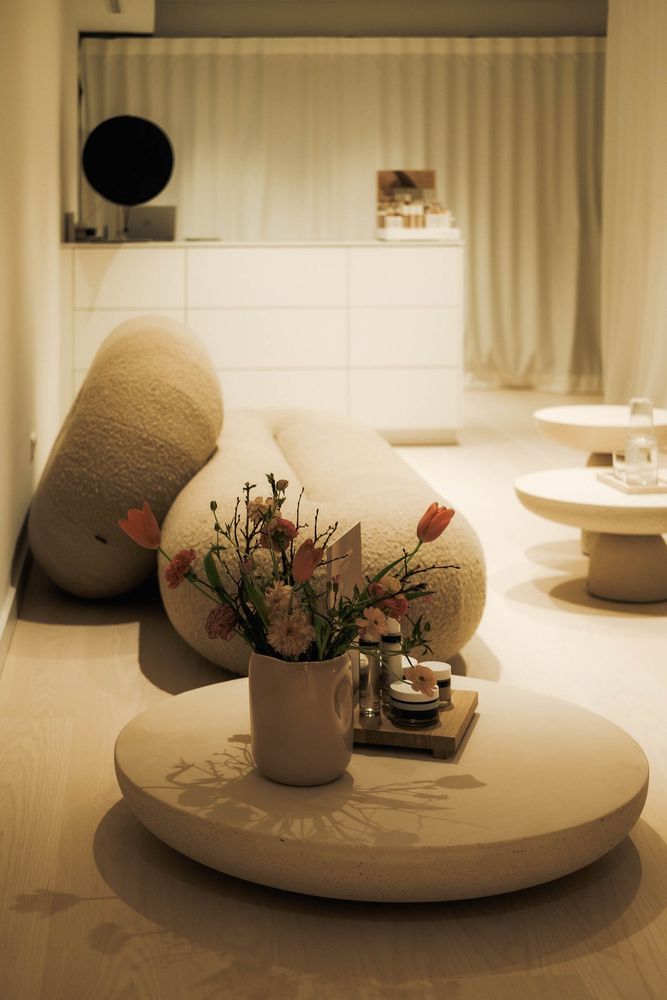 Runder Tisch mit Blumen, dahinter ein Sofa